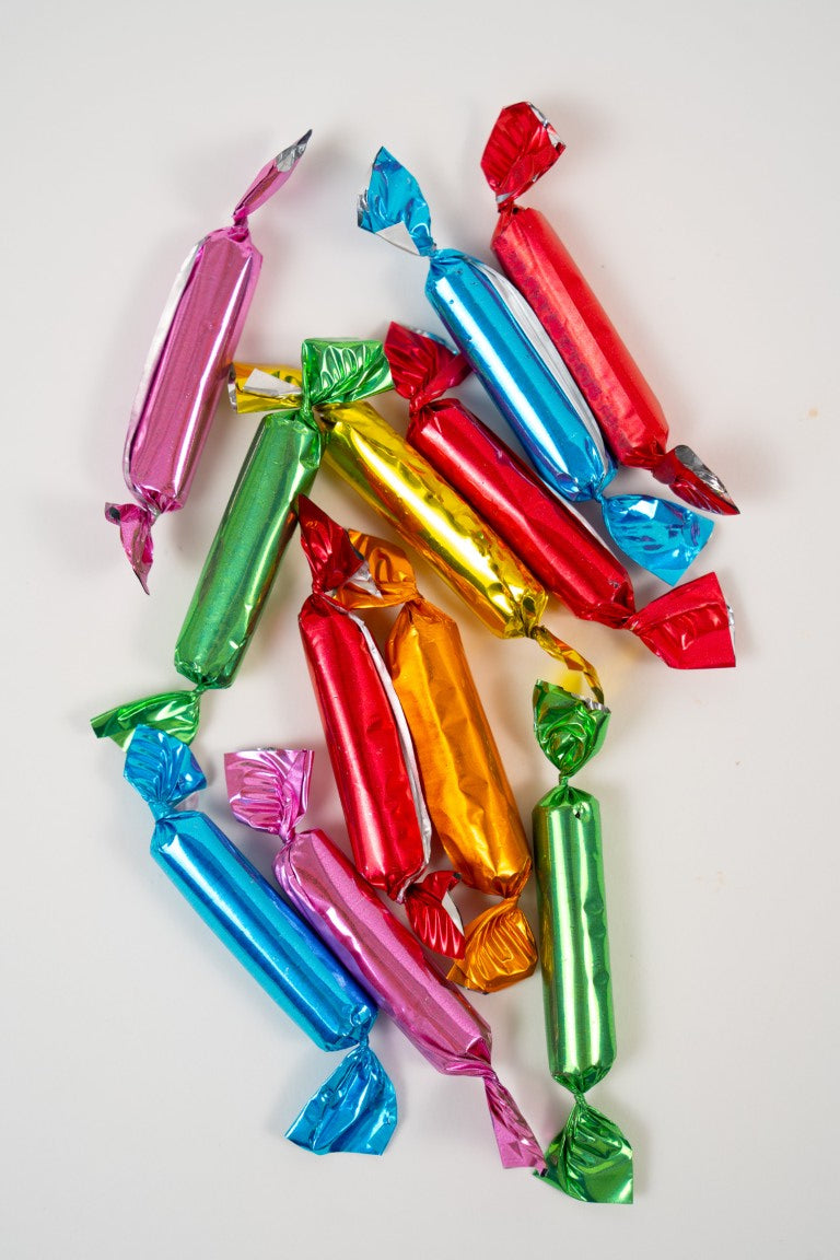 Zoom sur les mini bonbons aux fruits colorés et translucides. Texture lisse et brillante, confiserie artisanale de qualité.