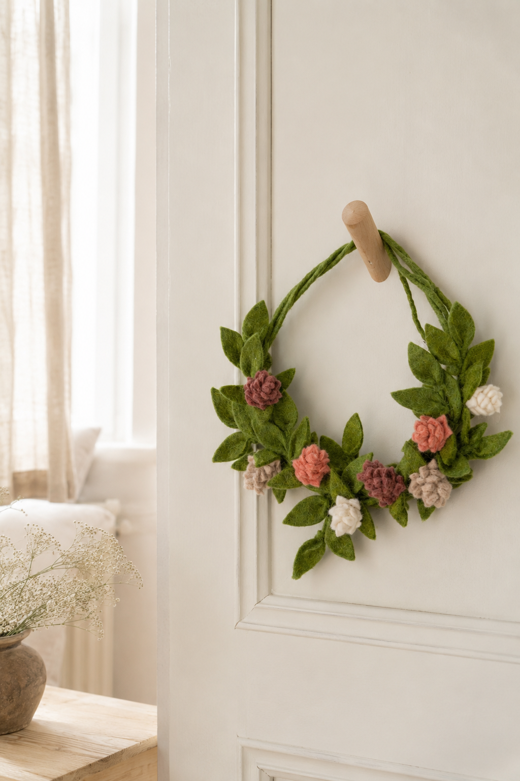 Gry & Sif felt rose door hanger styled on a cream interior door in soft natural light.