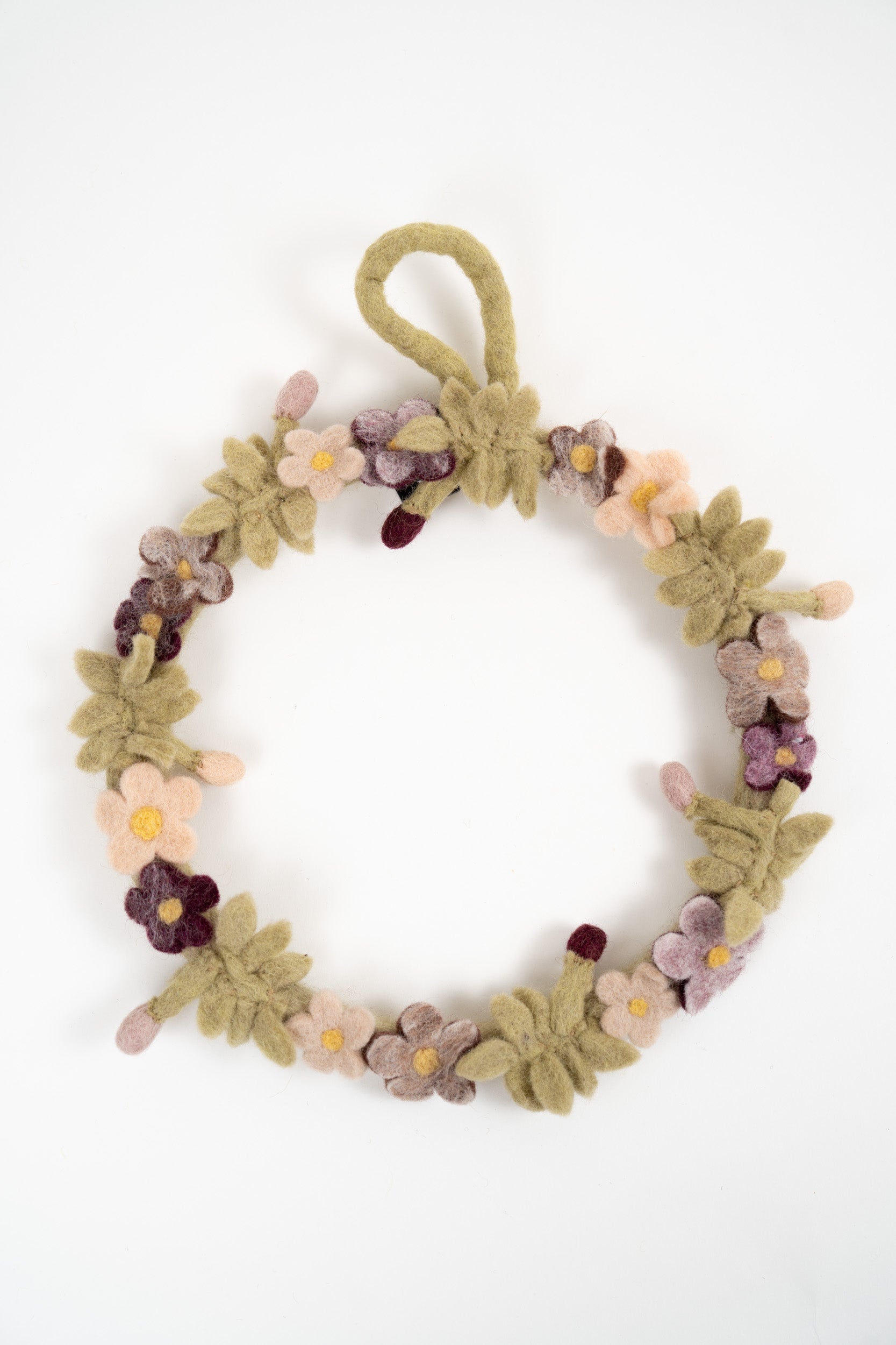 Handmade felt floral wreath with pink, mauve and burgundy flowers displayed on a white background
