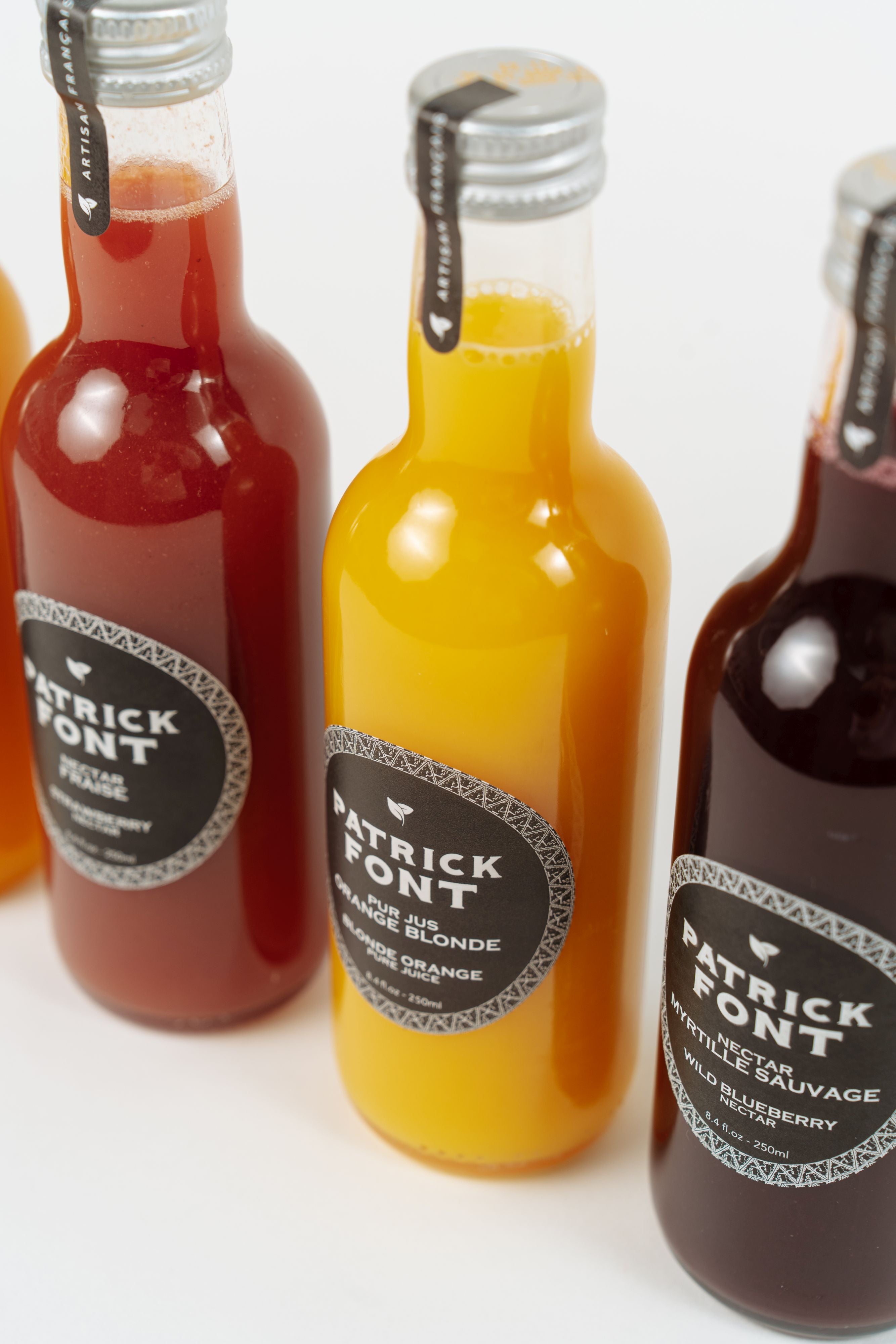 Assortiment de jus et nectars de fruits Patrick Font en bouteilles.