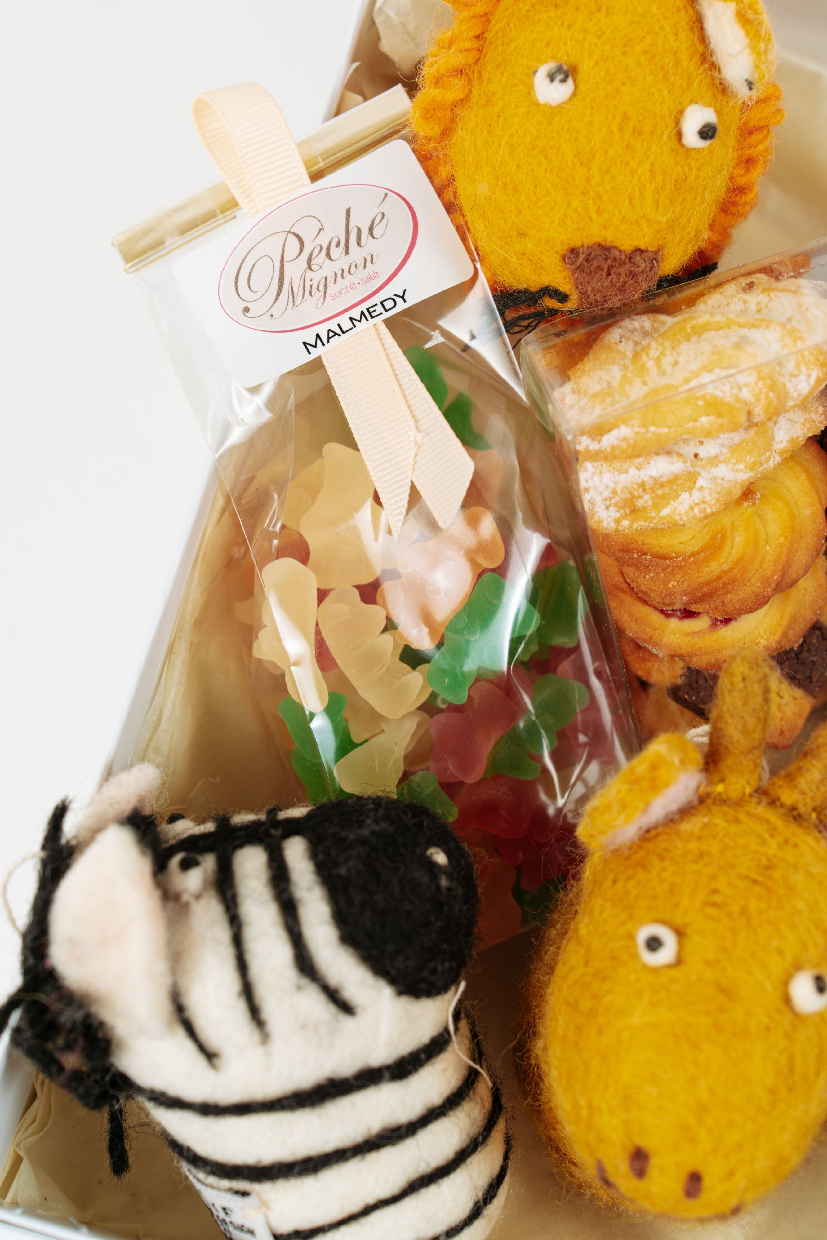 Biscuits, bonbons et animaux en laine dans coffret gourmand enfant