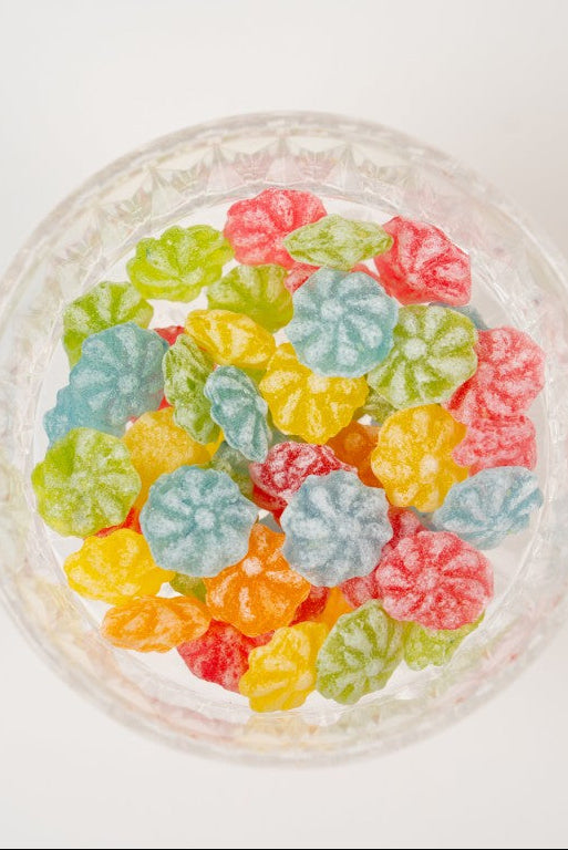 bonbons colorés naturels en forme de fleurs sur planche