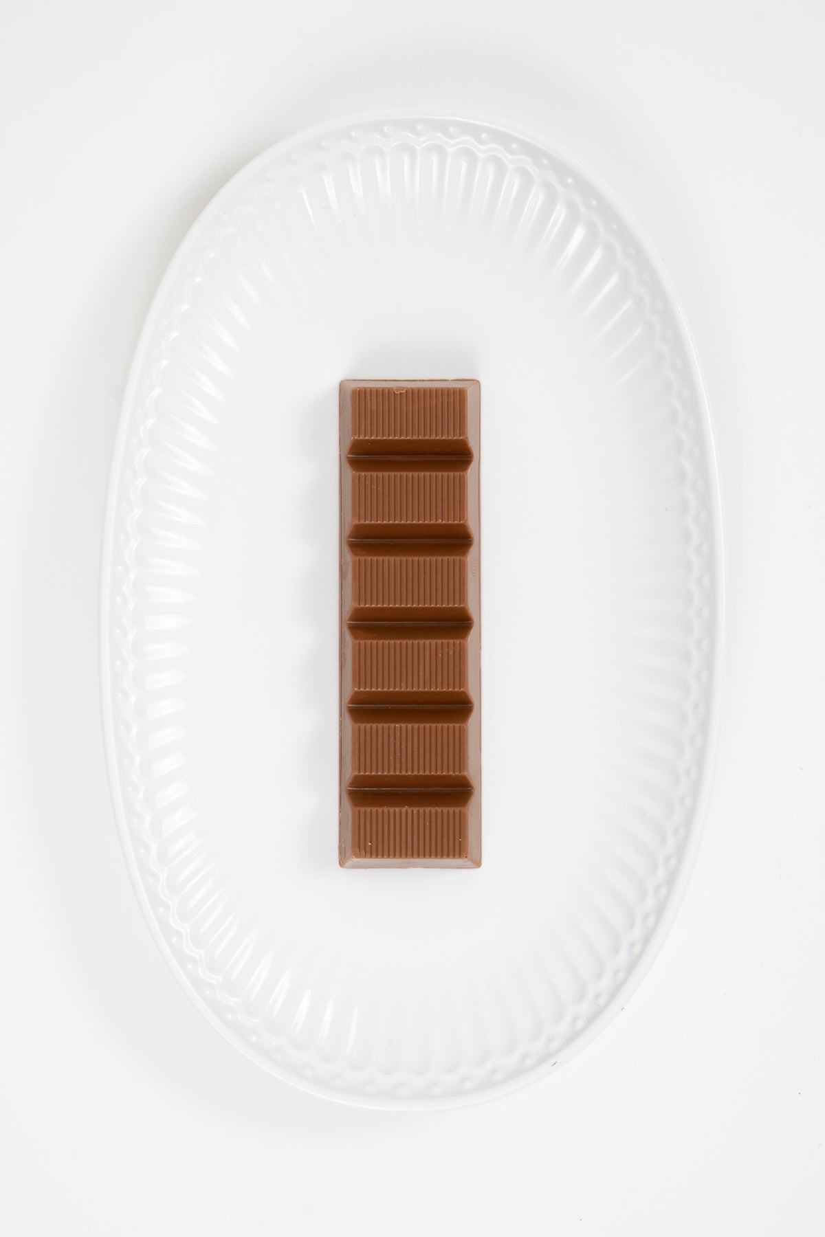 Whole milk chocolate pistachio kadayif bar on white plate