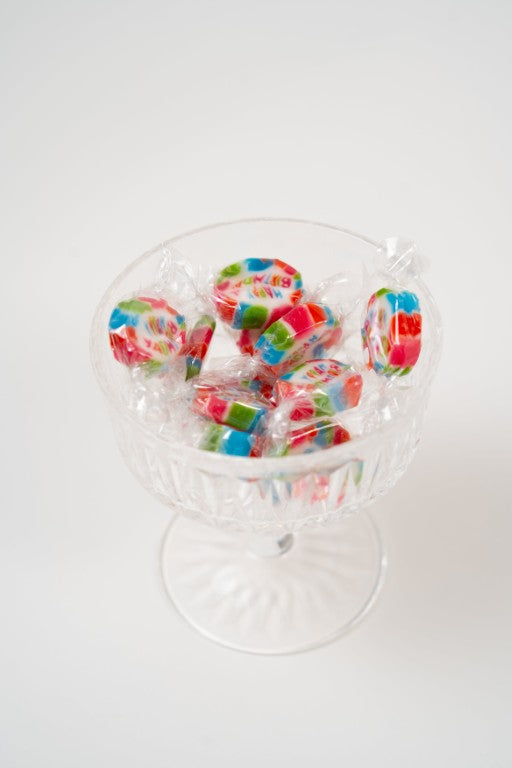 mini bonbons Happy Birthday colorés présentés dans une coupe transparente