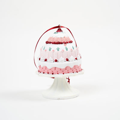 Ornement décoratif en forme de gâteau rose raffiné sur présentoir élégant.