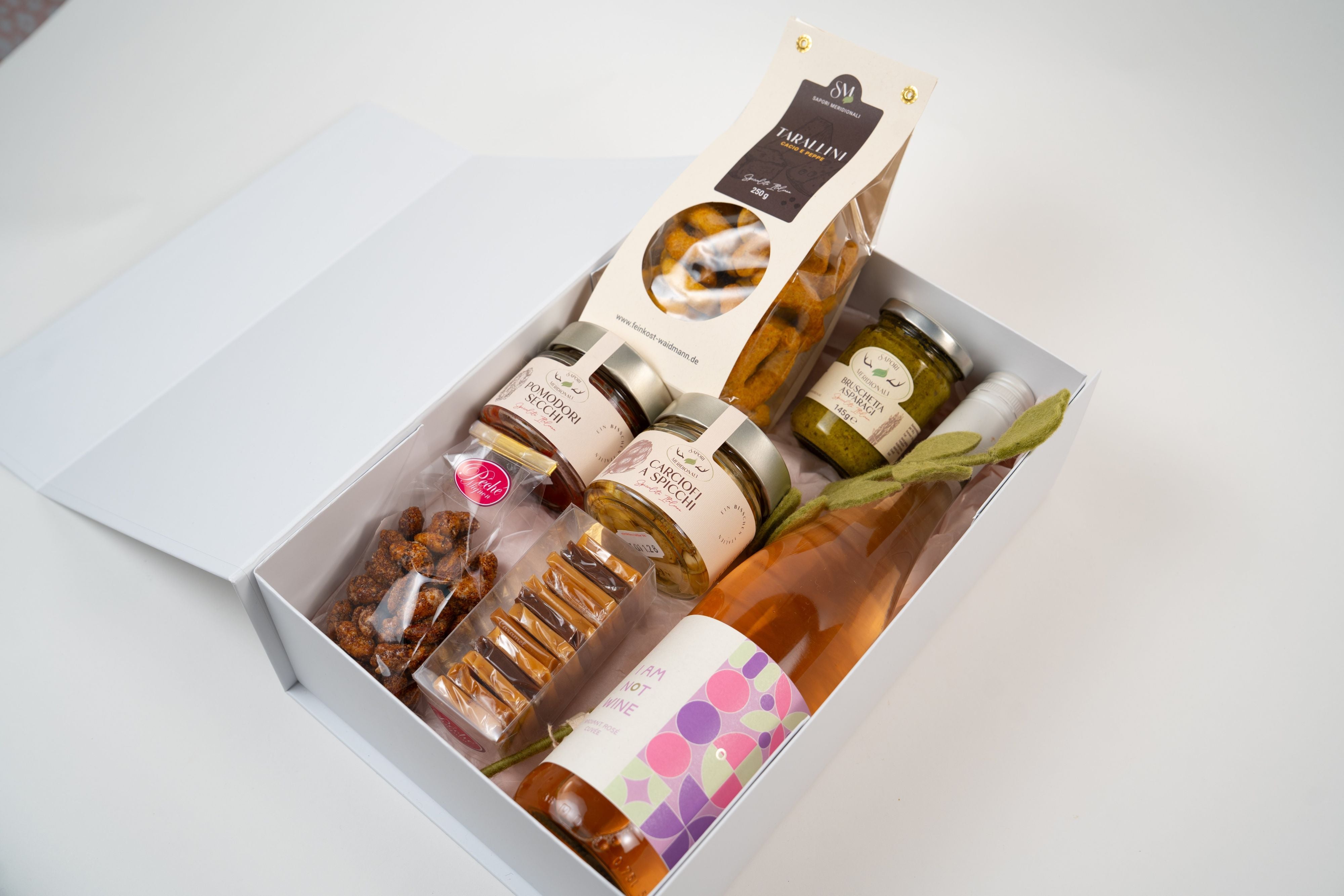 Open  Péché Mignon gourmet gift box with alcohol-free rosé, bruschetta spread, artichokes, taralli and sweets