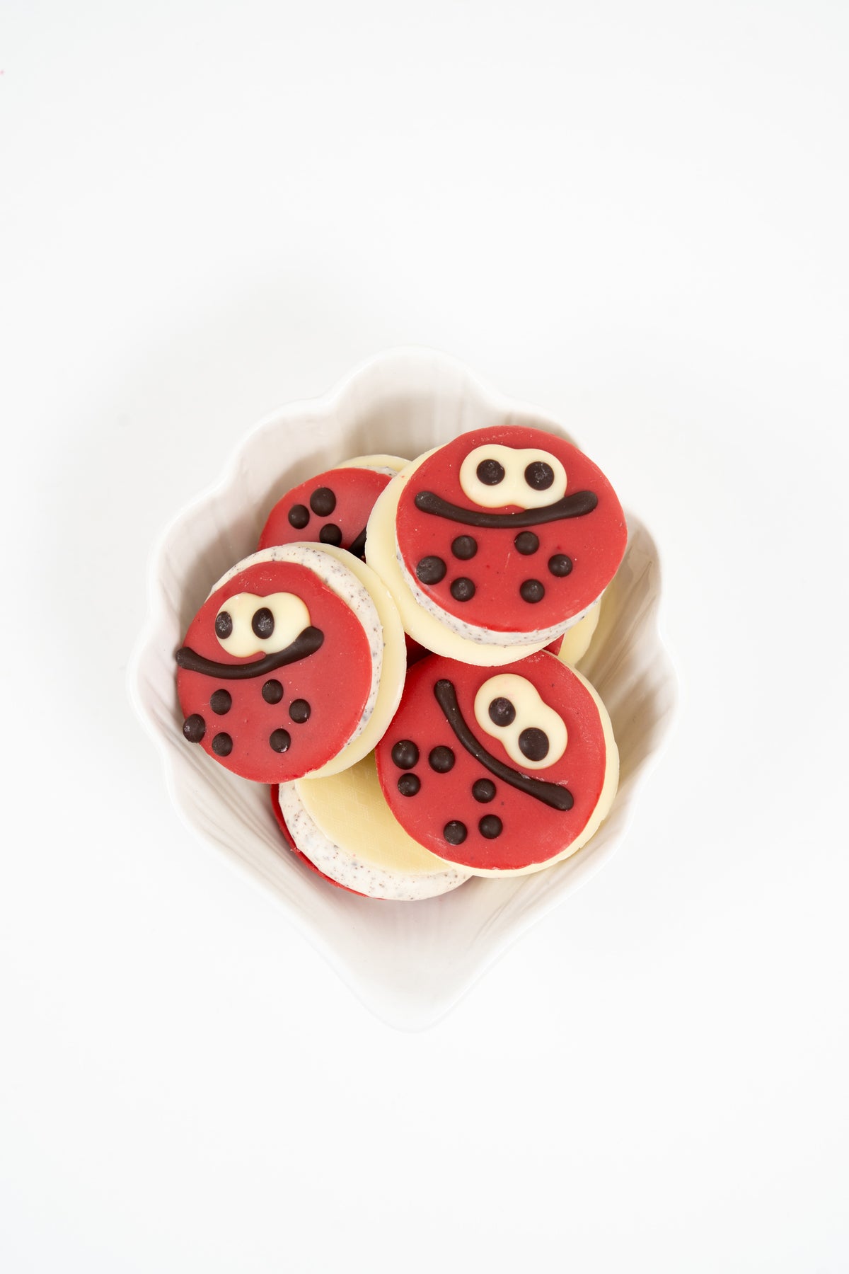 Macarons Ladybug Péché Mignon au chocolat et crème stracciatella, décorés façon coccinelle.