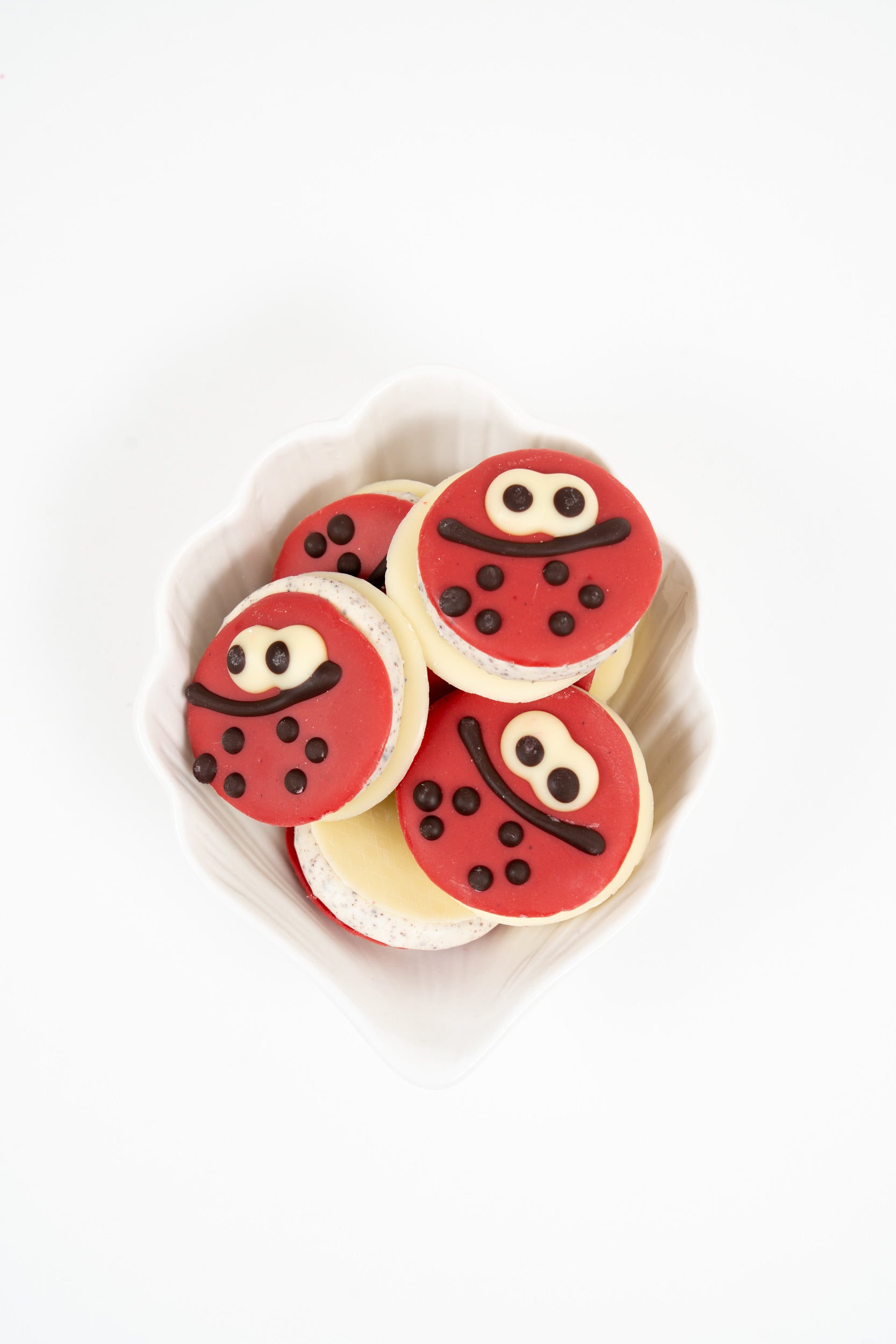 Macarons Ladybug Péché Mignon au chocolat et crème stracciatella, décorés façon coccinelle.