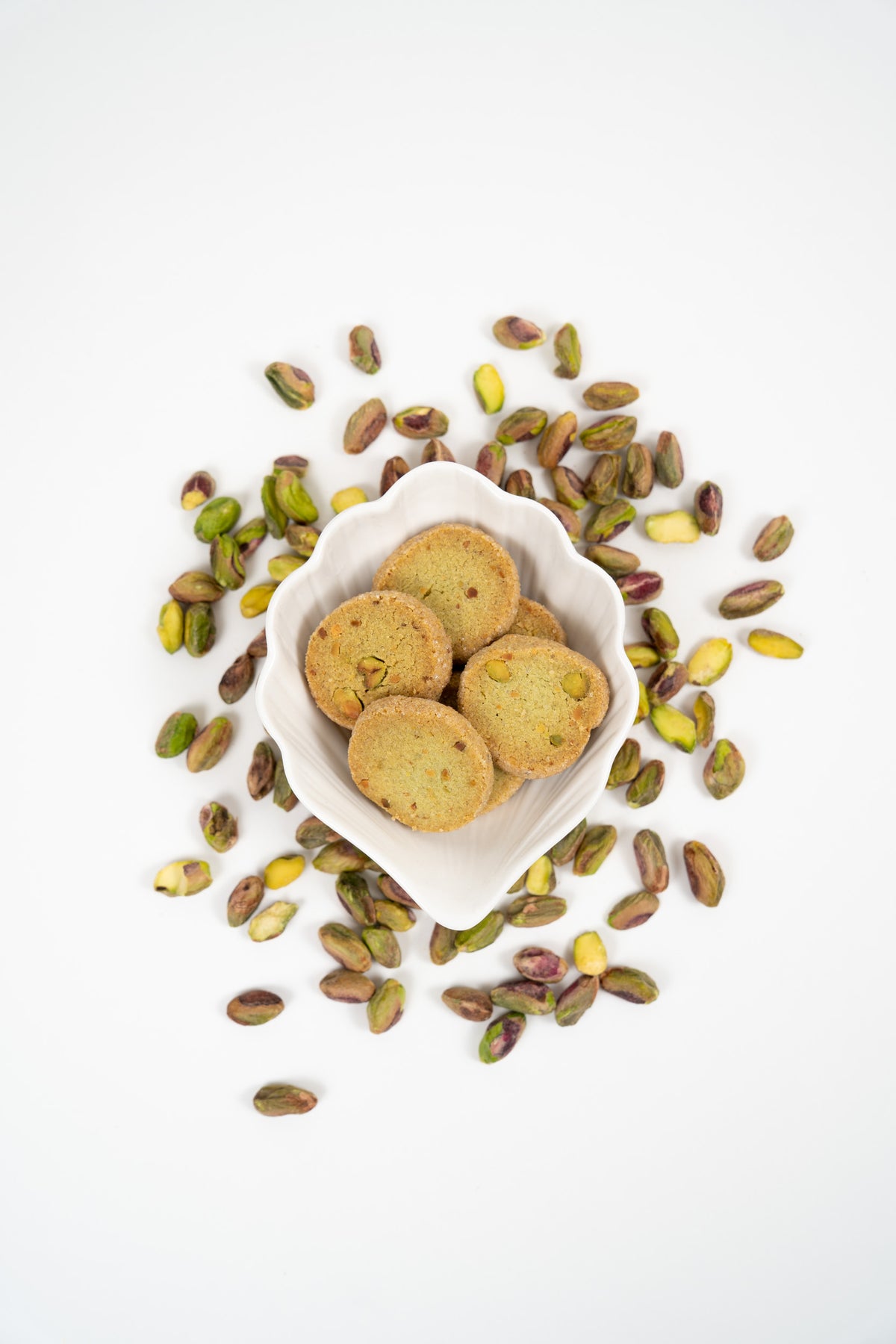 Artisan pistachio biscuits with whole pistachios in a bowl