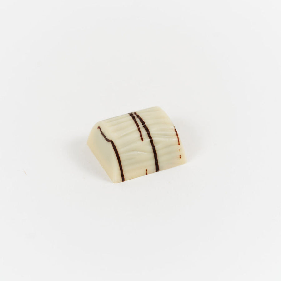 Artisan Belgian Croquantine praline in white chocolate with gianduja and biscuit, on a white background.