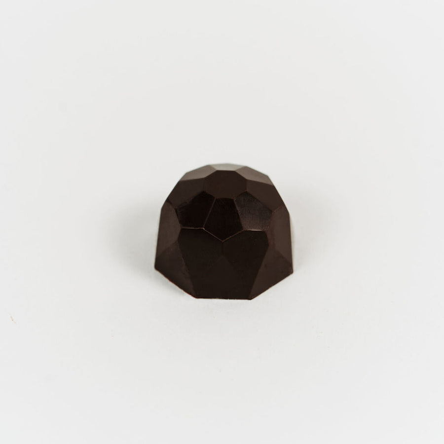 Artisan Belgian Diamant Fondant praline in dark chocolate with coffee praline, on a white background.