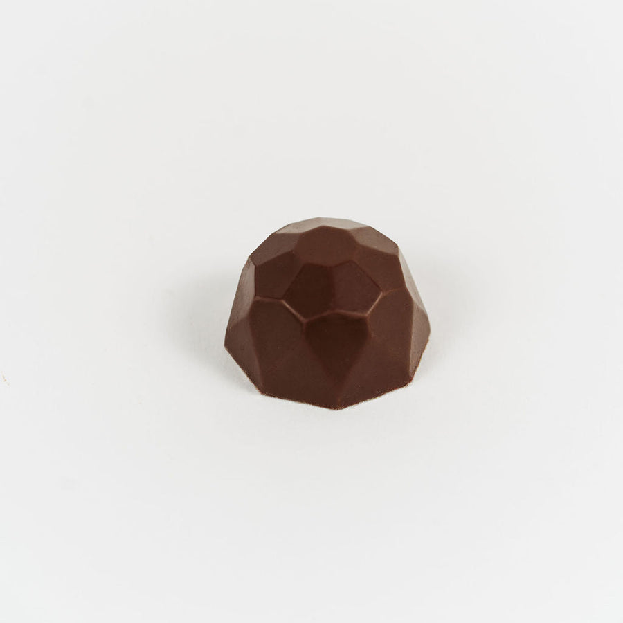 Artisan Belgian Diamant Lait praline in milk chocolate with coffee praline, on a white background.
