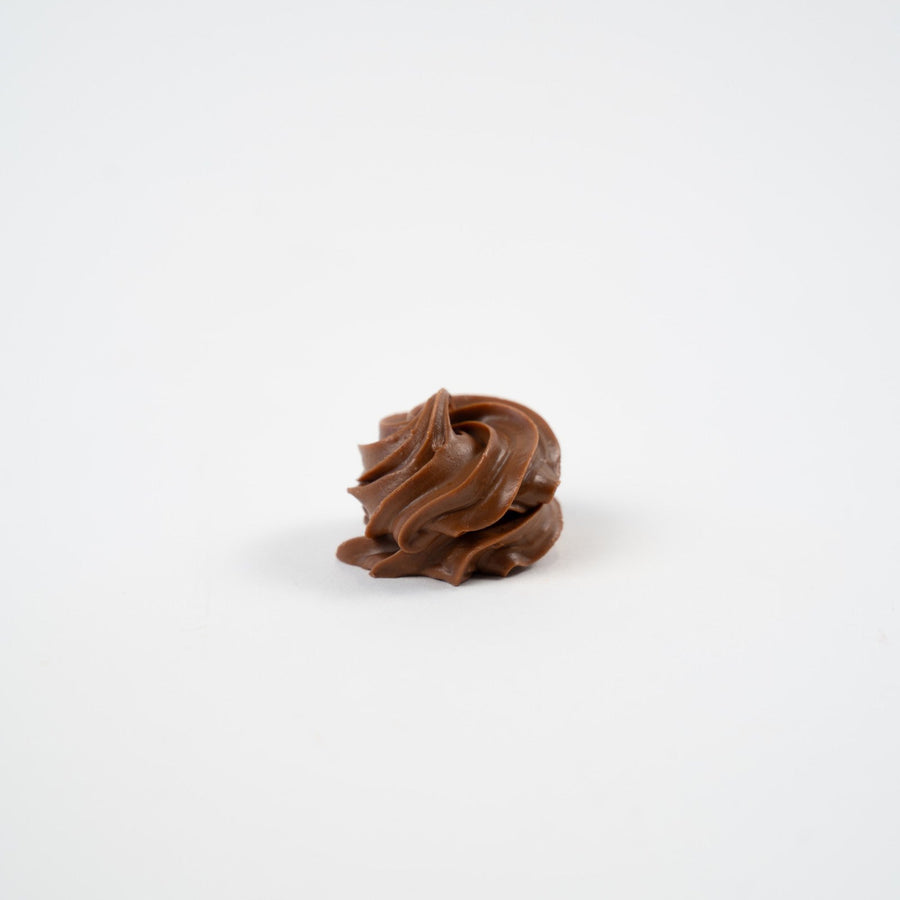 Artisan Belgian Figaro praline in milk chocolate with hazelnuts and gianduja, on a white background.