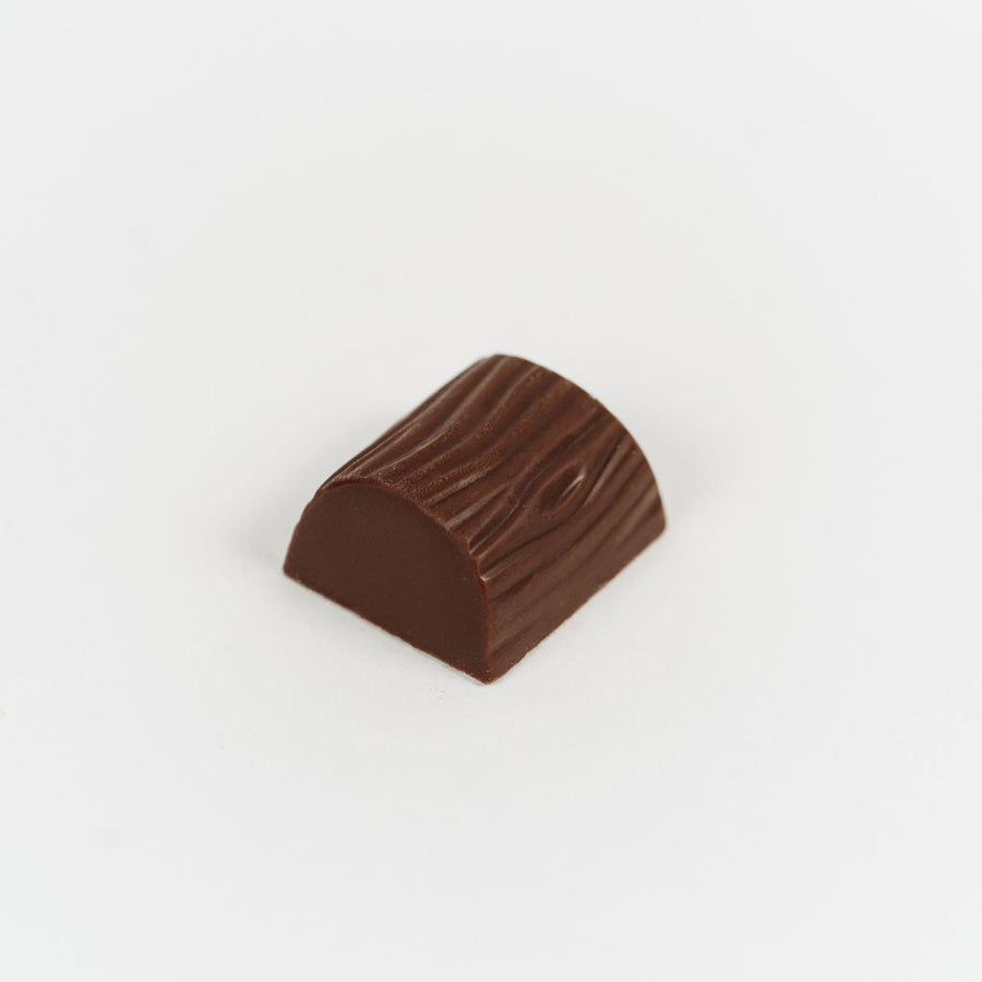 Artisan Belgian Lactée praline in milk chocolate with almond praline, on a white background.
