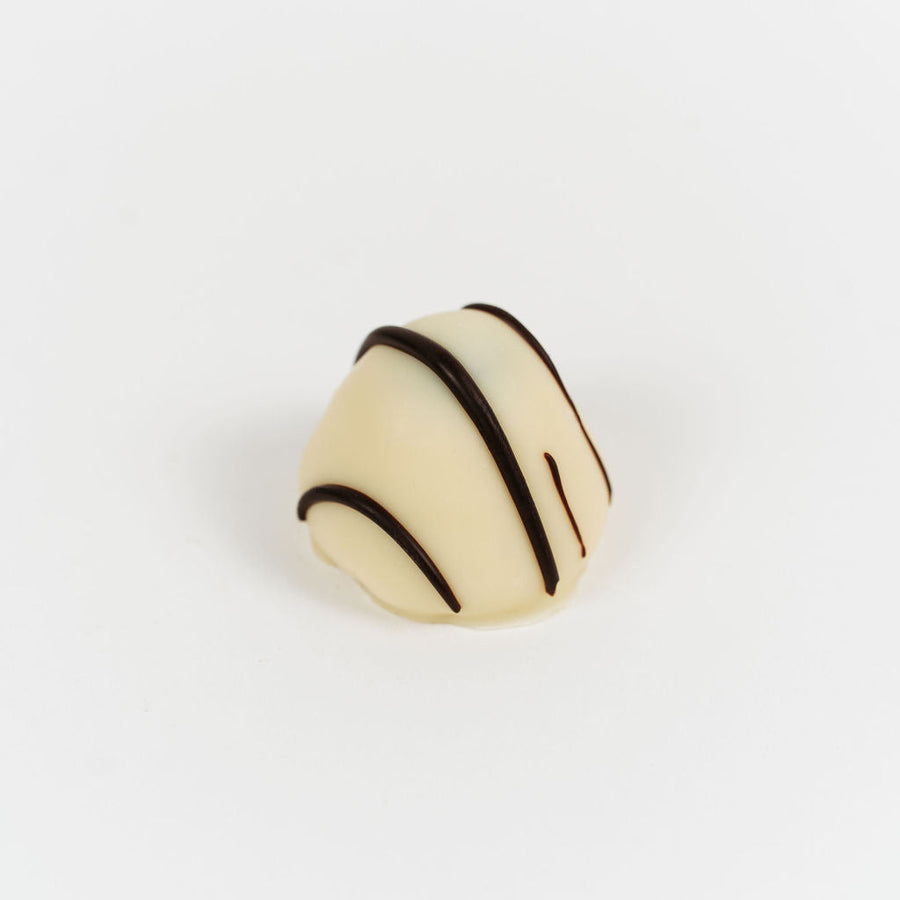 Artisan Belgian Manon Praliné praline in white chocolate with fresh cream, praline and hazelnut, on a white background.