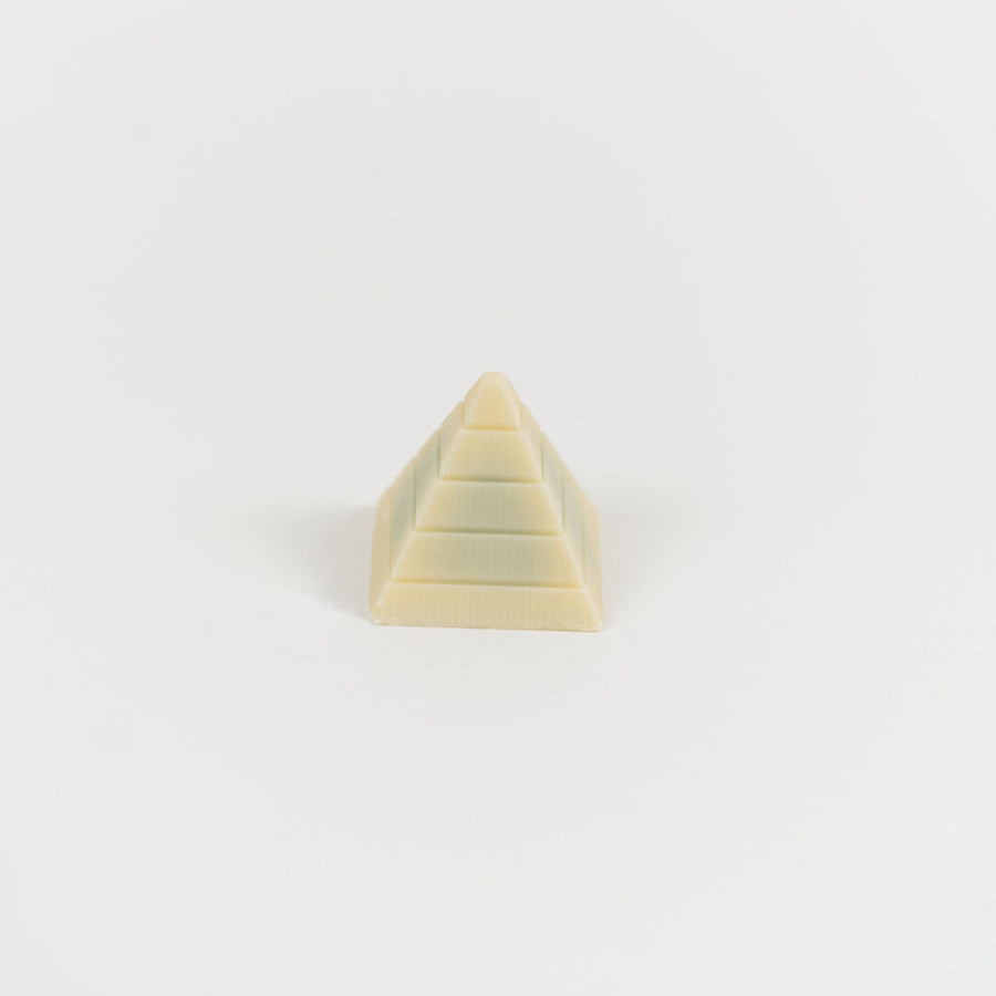 Artisan Belgian Pyramide praline in white chocolate with dark ganache, on a white background.