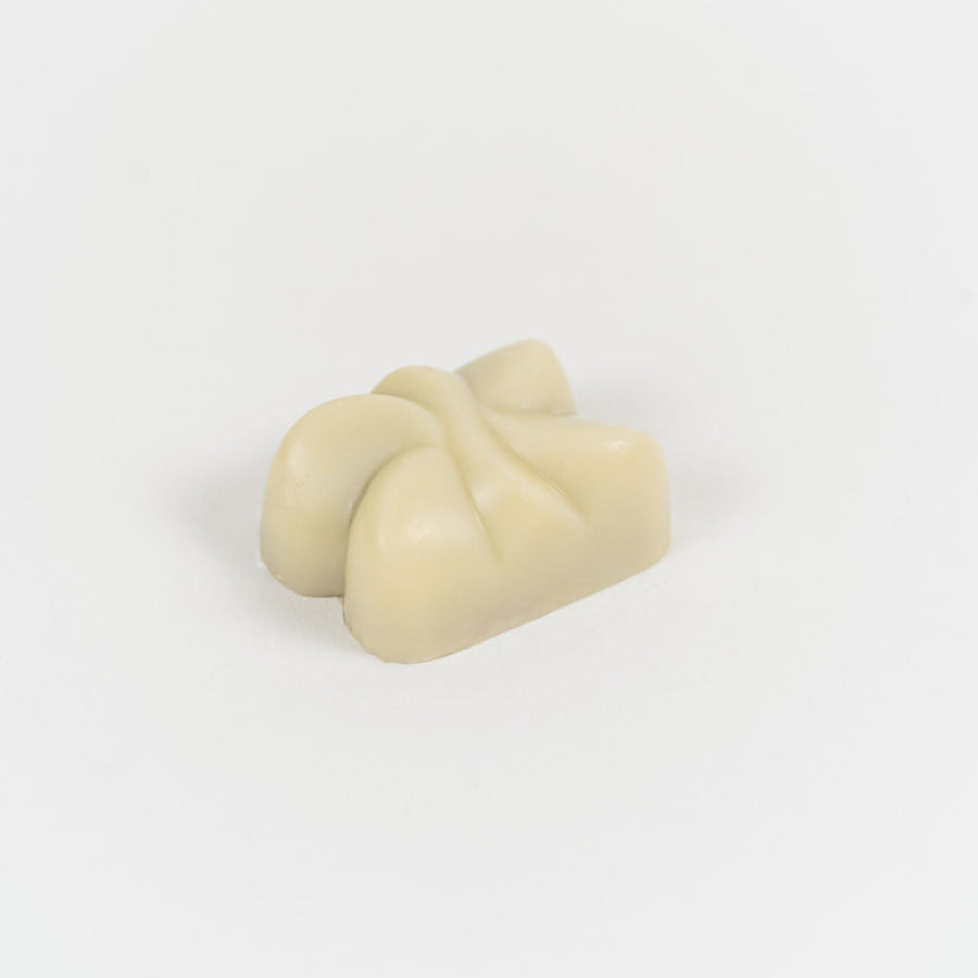 Artisan Belgian Tarentelle praline in white chocolate with almond praline, on a white background.