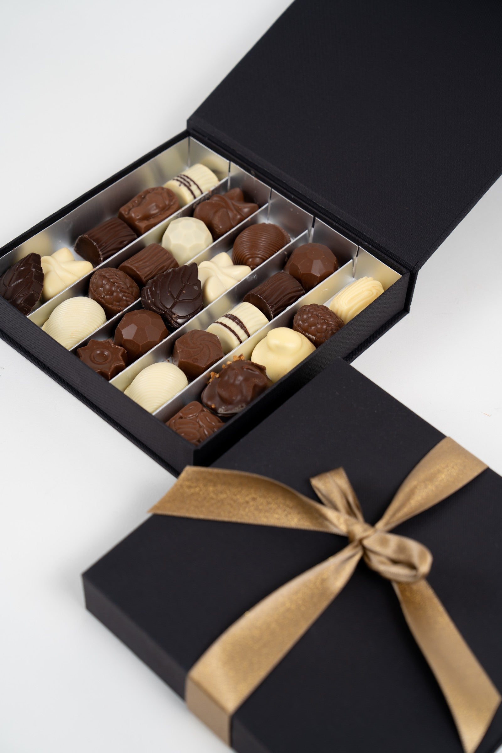 Pralines artisanales belges dans un coffret doré Péché Mignon