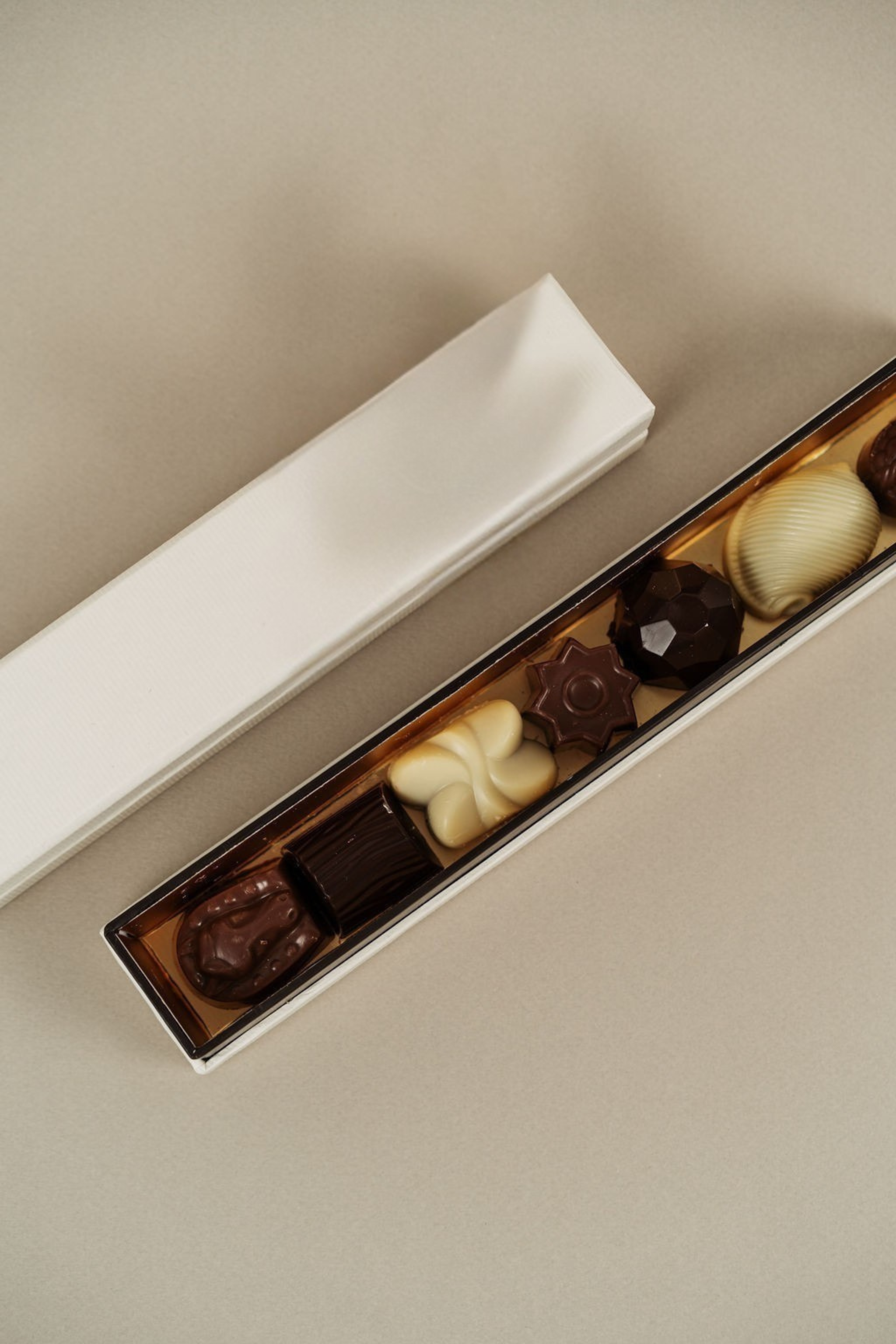 Coffret fin de pralines artisanales Péché Mignon avec assortiment de chocolats raffinés et textures gourmandes.