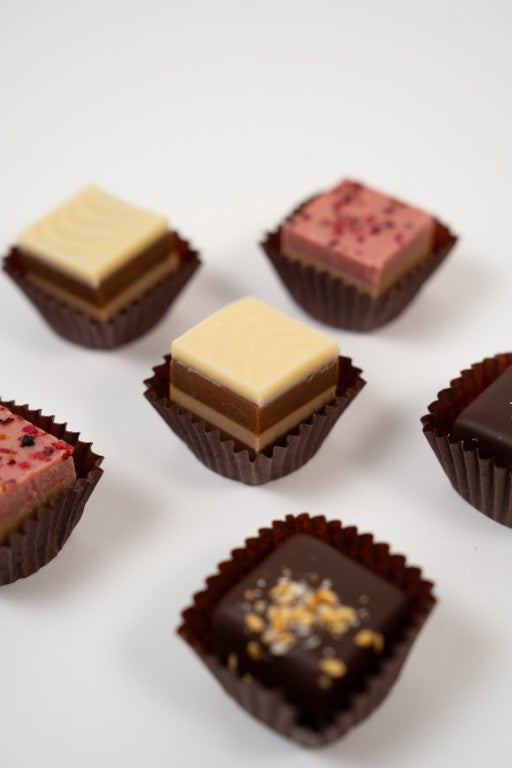 Assortiment de pralinés nougat vegan aux noisettes et framboises, cadeau gourmand.