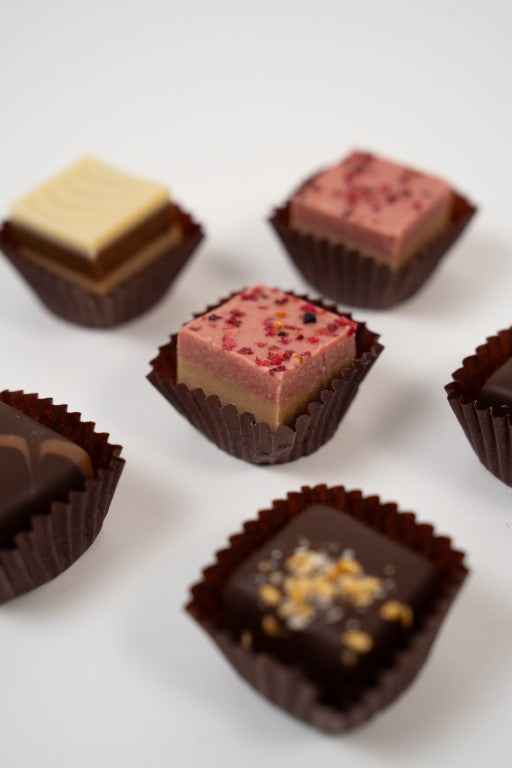 Assortiment de pralinés nougat vegan aux noisettes et framboises, cadeau gourmand.