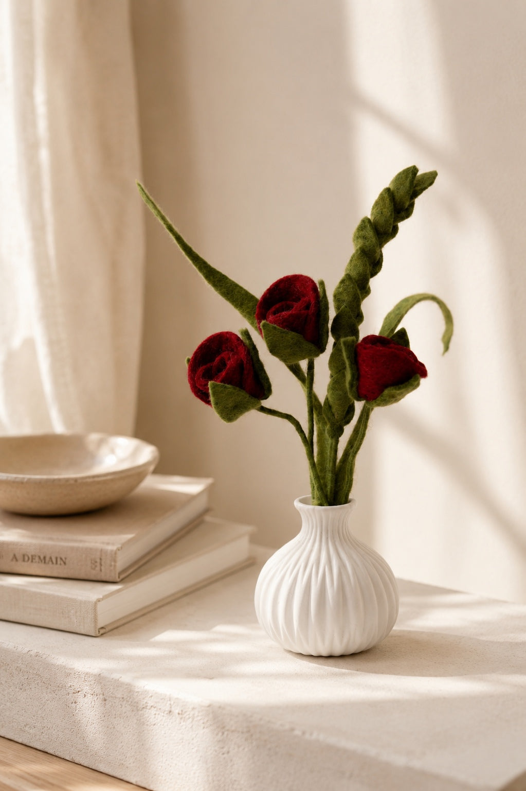 Bouquet de roses rouges en feutre dans un vase blanc en décoration minimaliste