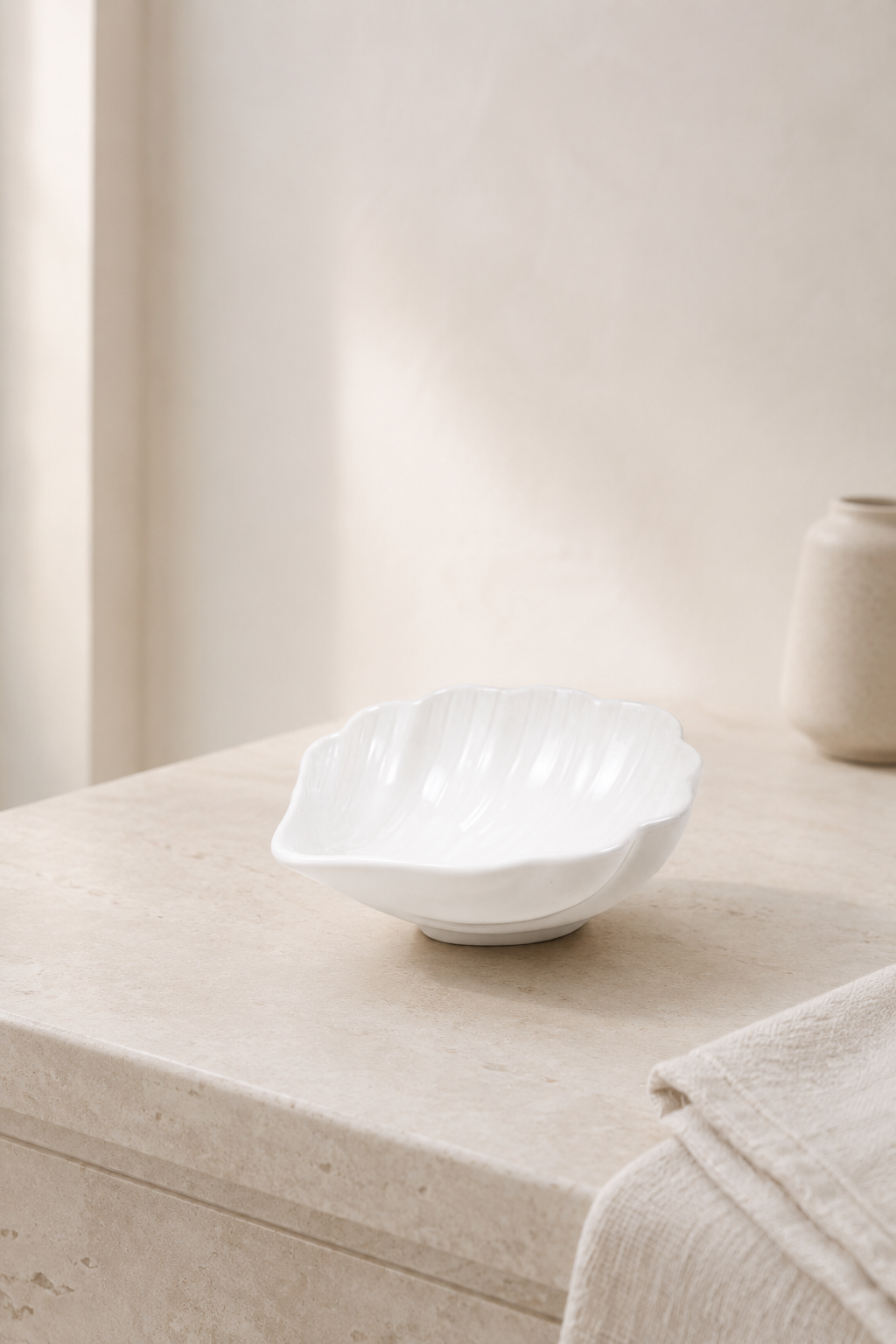 White ceramic shell bowl with scalloped edges on a clean white background.