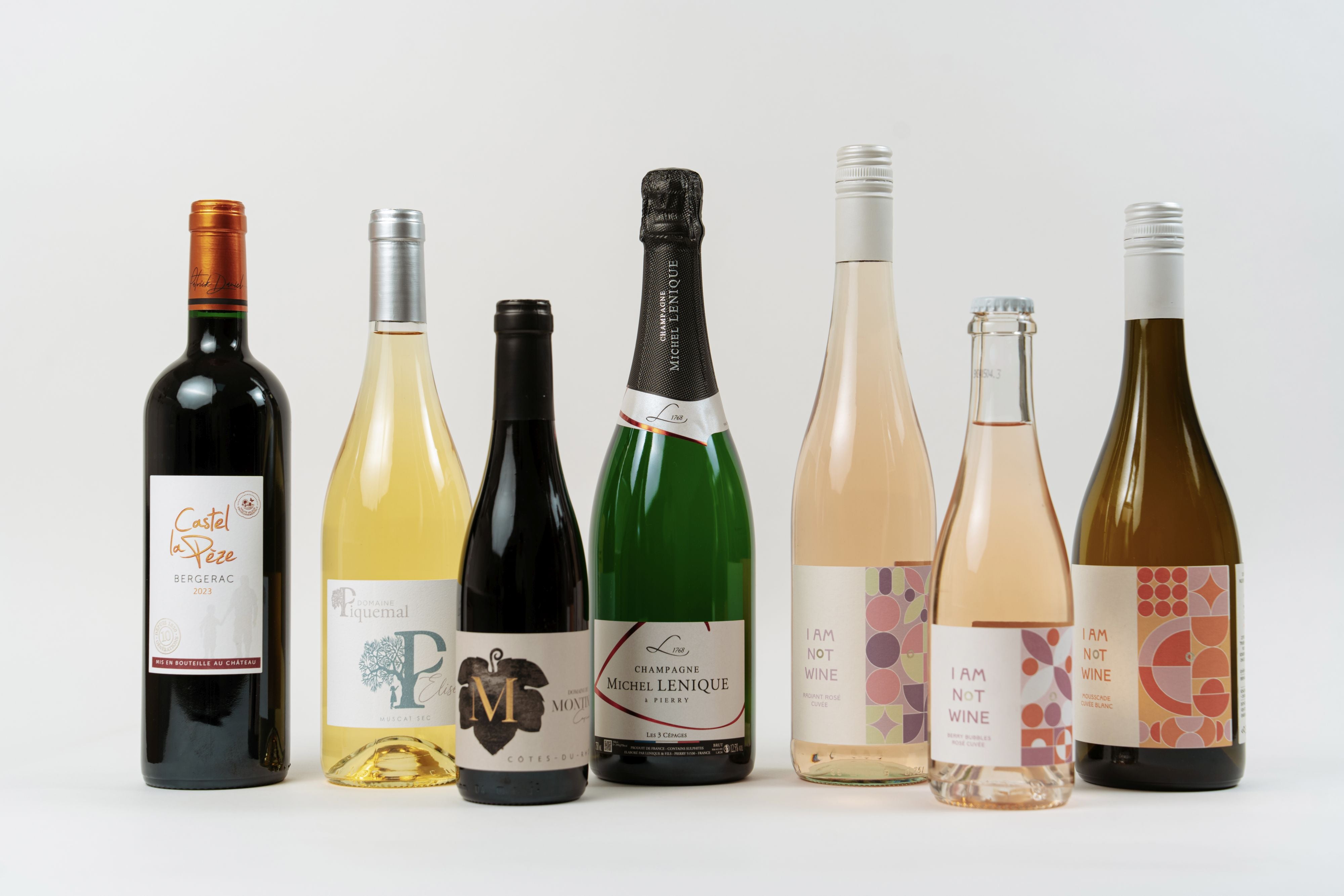 Sélection de vins et champagnes premium alignés, incluant champagne, vin rouge, blanc et rosé.