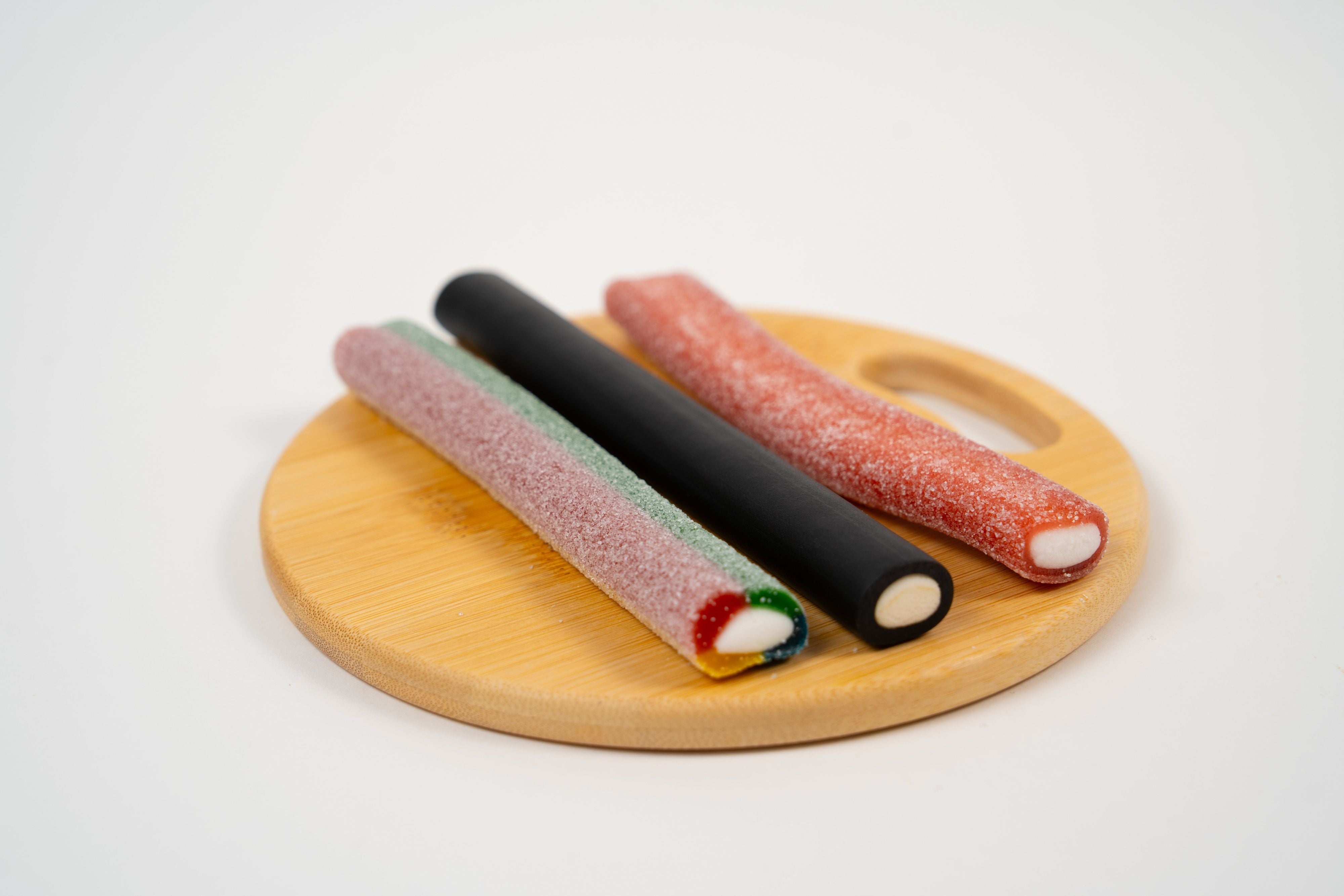 Gros plan sur la texture acidulée et le cœur de réglisse tendre du bâton Tutti Frutti.